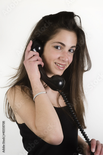 Photo: Teenage girl smiling while talking on the phone Teenage girl smiling while talking on the phone