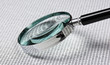 magnifying glass on a binary code