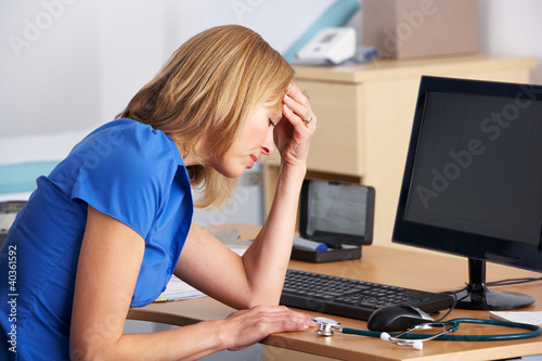 Photo: Stressed UK doctor sitting at desk Stressed UK doctor sitting at desk