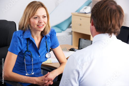 Photo: Female UK doctor talking to male patient Female UK doctor talking to male patient