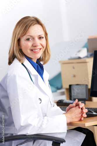 Photo: Portrait American doctor sitting at desk Portrait American doctor sitting at desk