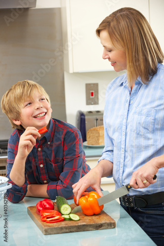 Photo: Mother and son preparing food in domestic kitchen Mother and son preparing food in domestic kitchen