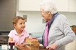 Grandmother and granddaughter preparing food in kitchen