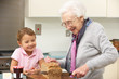 Grandmother and granddaughter preparing food in kitchen