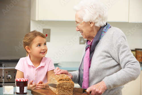 Photo: Grandmother and granddaughter preparing food in kitchen Grandmother and granddaughter preparing food in kitchen
