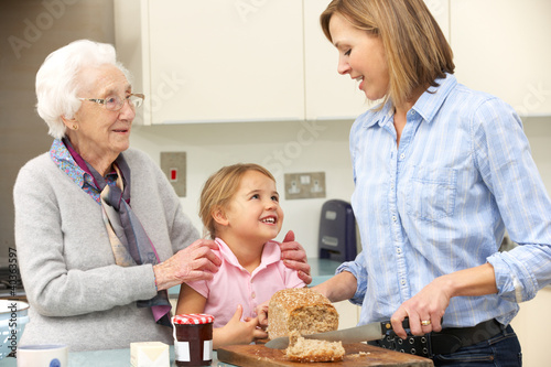 Photo: Multi-generation family preparing food in kitchen Multi-generation family preparing food in kitchen