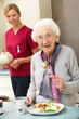 Photo: Senior woman with carer eating meal at home Senior woman with carer eating meal at home