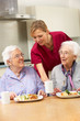 Senior women with carer enjoying meal at home