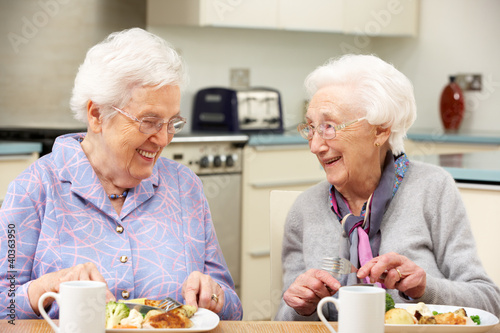 Photo: Senior women enjoying meal together at home Senior women enjoying meal together at home