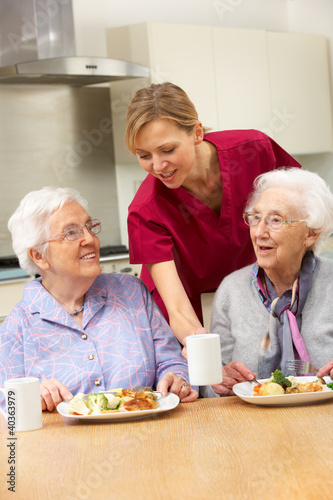 Photo: Senior women with carer enjoying meal at home Senior women with carer enjoying meal at home