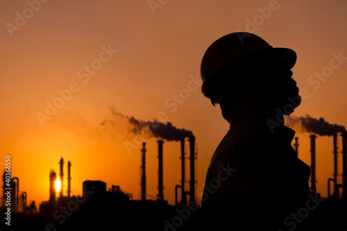 Foto: the silhouette of oil refinery worker at sunset the silhouette of oil refinery worker at sunset