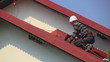 Man paints roof of a private house