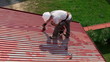 Man paints roof of a private house
