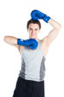 young boxer in gray shirt and blue boxing gloves
