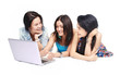 Three girls-students with laptop sitting on white background Three girls-students with laptop sitting on white background