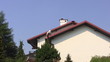 Man paints roof of a private house