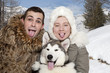 Young couple with a malamute puppy Young couple with a malamute puppy