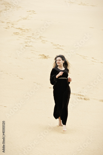 Photo: Smiling woman running in desert Smiling woman running in desert