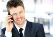 Smiling man using an office phone Smiling man using an office phone