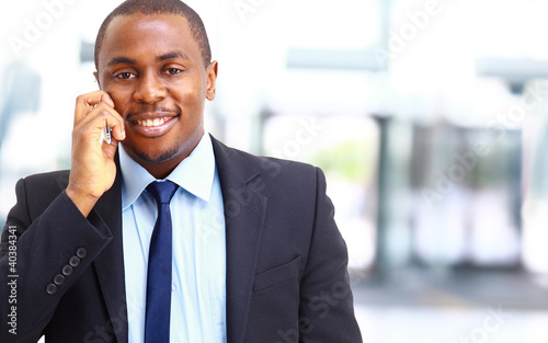 Photo: smiling businessman on the phone in his office smiling businessman on the phone in his office