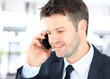 Smiling man using an office phone Smiling man using an office phone