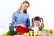 Foto: Young mother cooking at home with her daoghter Young mother cooking at home with her daoghter