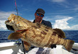 Happy  fisherman holding a grouper