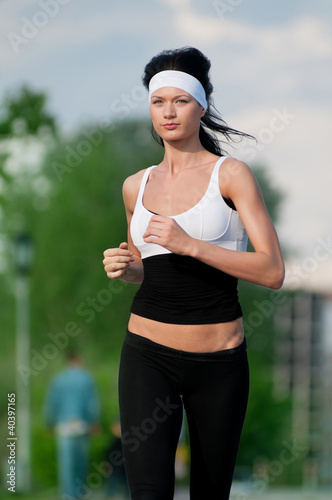 Photo: Woman running in green park Woman running in green park
