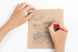 man hands draw picture with landscape on brown paper