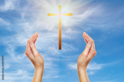 Photo: hands praying with a wooden cross hands praying with a wooden cross