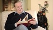 senior man reading a book and drinking whisky