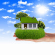 House and human hand against blue sky