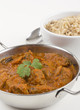 Indian Meat Madras served with pilau rice on a white background