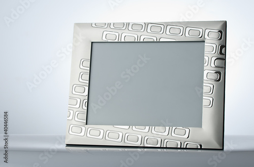 Illustration: Blank silver picture frame at the table with place for your own Blank silver picture frame at the table with place for your own