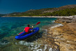 Man rowing in inflatable kayak at Adriatic sea. Hvar, Croatia Man rowing in inflatable kayak at Adriatic sea. Hvar, Croatia