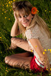 junge Frau mit Blume im Haar in der Wiese
