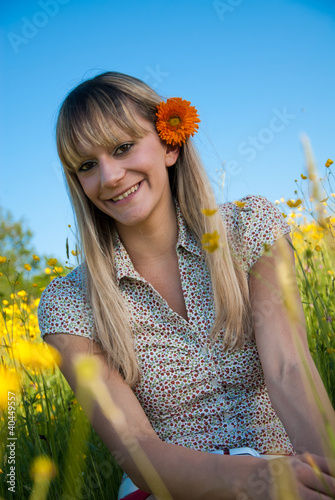 Photo: junge Frau mit Blume im Haar in der Wiese junge Frau mit Blume im Haar in der Wiese