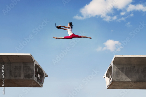 Photo: Attractive woman jumping with laptop Attractive woman jumping with laptop