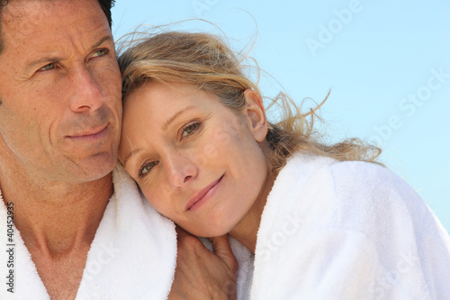 Photo: Couple in bathrobes showing affection Couple in bathrobes showing affection
