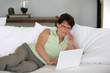Mature woman using her laptop on a sofa Mature woman using her laptop on a sofa
