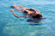 woman in bikini swims in sea