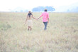 man and women wearing a hat walking in the grass field