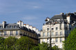 Immeubles parisiens, arbres et ciel bleu.