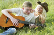 A guy playing a song on his guitar for his girlfriend.