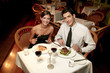 A couple in dinner wear celebrating their anniversary by eating in the restaurant.