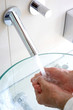 A pair of hands cupping the water from the tap.