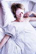 Photo: A woman sleeping with her eyes covered in the bedroom. A woman sleeping with her eyes covered in the bedroom.