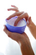 Photo: A pair of hands taking a body cream. A pair of hands taking a body cream.
