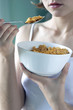 Photo: A woman in white camisole eating her breakfast cereal. A woman in white camisole eating her breakfast cereal.