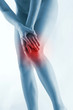 Waist down shot of a naked woman touching her aching knee.
